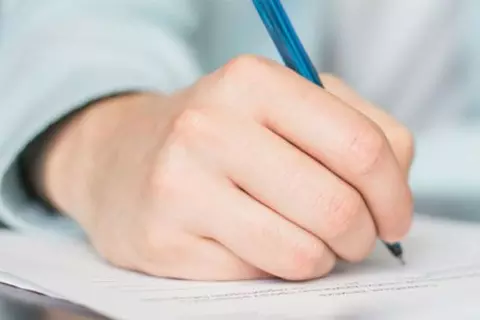 Detailaufnahme einer Person, die mit einem Stift schreibt