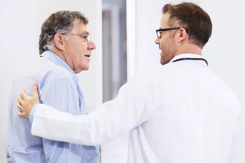Arzt im Gespräch mit älterem Patienten