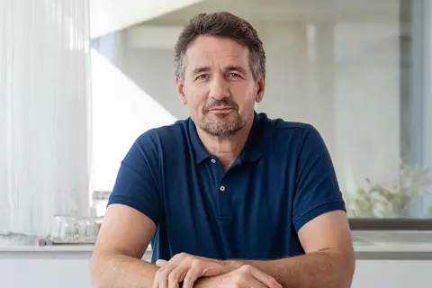 Mann schaut in Kamera und lächelt