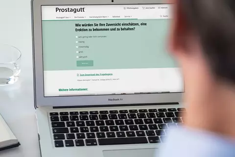Mann sitzt vor Laptop und führt Selbsttest zu Errektionsstörungen durch