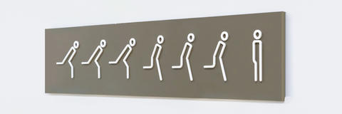 Schild an der Wand zur Toilette mit dem Symbol einer Person, die auf die Toilette rennt